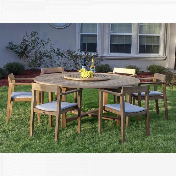 70238 Buckingham Horizon teak dining set with 2 wine bottles and yellow flowers on lazy susan in center of table and optional seat cushions on grass landscape plants and house in back