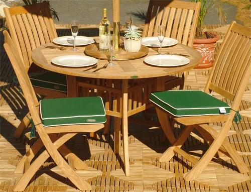 alt="70056 Hyatt Barbuda 5 piece Dining Set with 4 white plate place settings and 4 wine glasses bottle of wine potted plant on top and optional seat cushions on teak tiles and 2 plants in back"