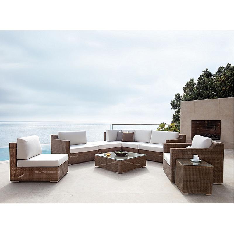 alt="70240 malaga nine piece synthetic woven wicker set with bowl apples coffee cup on patio with glass balcony outdoor fireplace and trees in background overlooking ocean and blue sky"