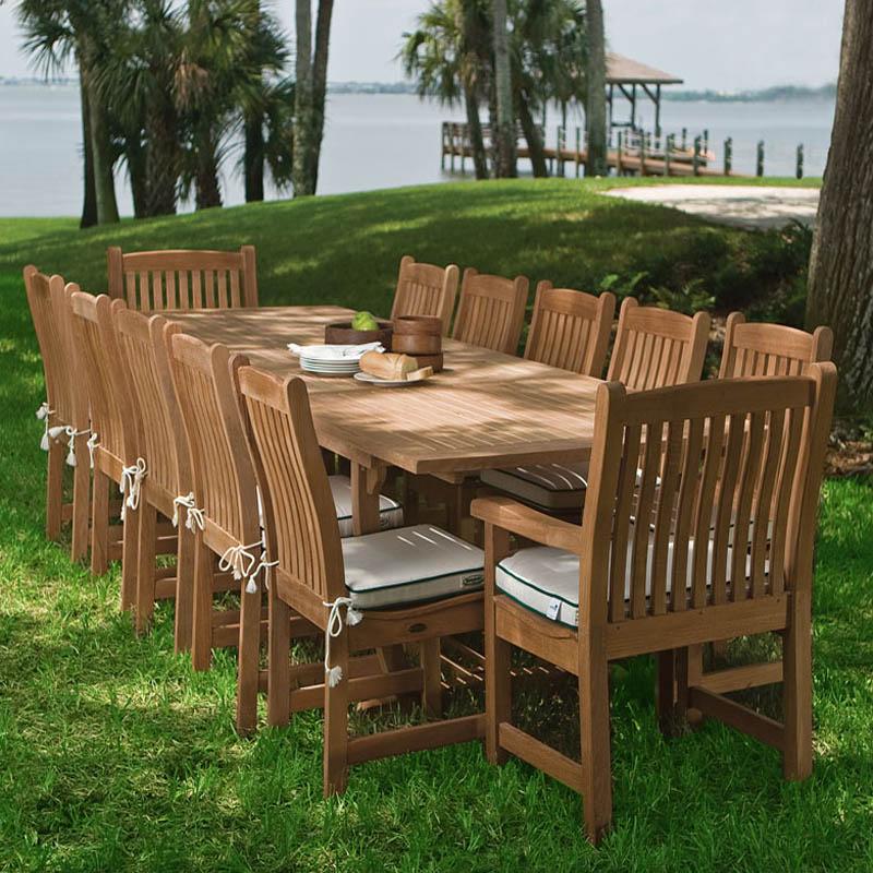 alt="70891 veranda grand extension table with veranda dining and side chairs with optional seat cushions on grass by lake"
