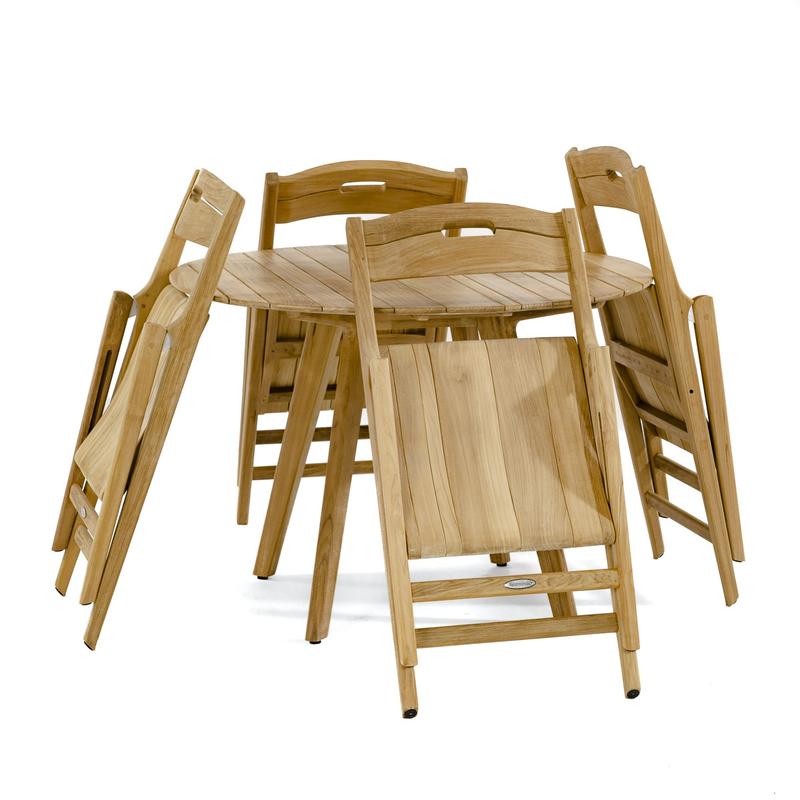 alt="70519 Surf Round Teak Dining Table Set of a 42 inch Round Teak Dining Table and 4 Surf folding chairs folded flat leaning against table side view on white background"