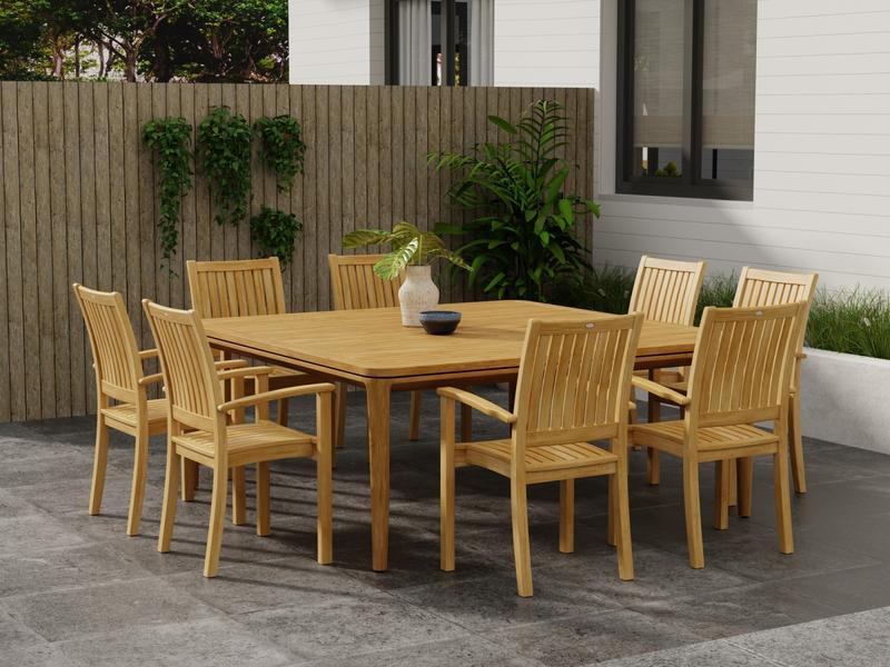 alt="70896 Veranda Sussex Dining Set for 8 with a bowl and vase on table top on patio surrounded by landscaping plants and tree with wood panel divider with hanging plants in background "