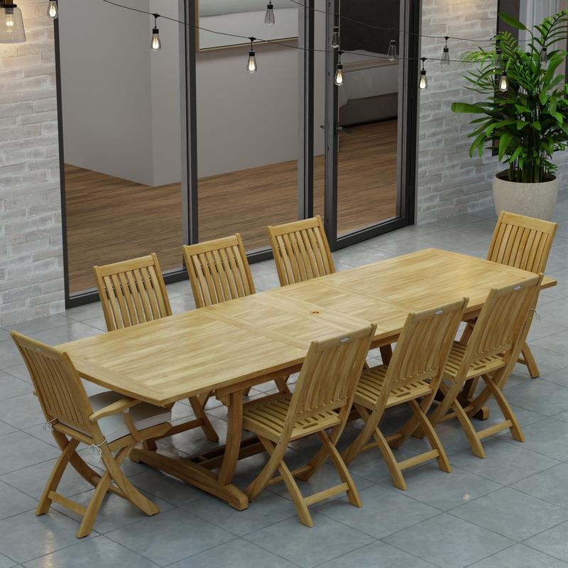 alt="70794 Veranda Barbuda Teak 9 pc Dining Set of Grand Veranda Dining Table and 2 Barbuda Armchairs and 6 Side Chairs aerial view on a patio with patio lights and glass doors in background"